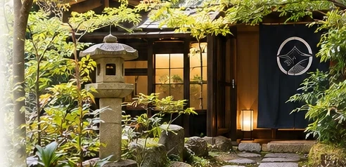 Stone lantern and noren curtain at the entrance of a Japanese guesthouse